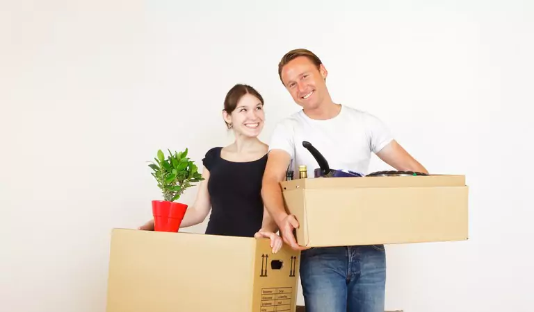 couple with some boxes inside of a house
