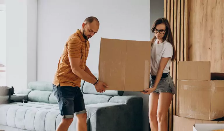 couple lifting a heavy cardboard box